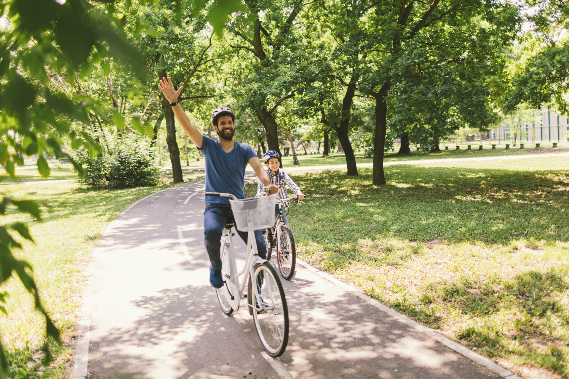 Father and son riding bicycle in the public park together - Unique Ideas for Spring Break in Orlando